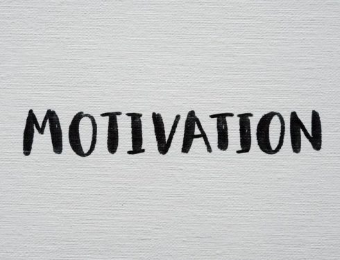 Inspirational word 'Motivation' in black on a white textured canvas background.